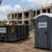 Construction site with dumpster and porta potty.